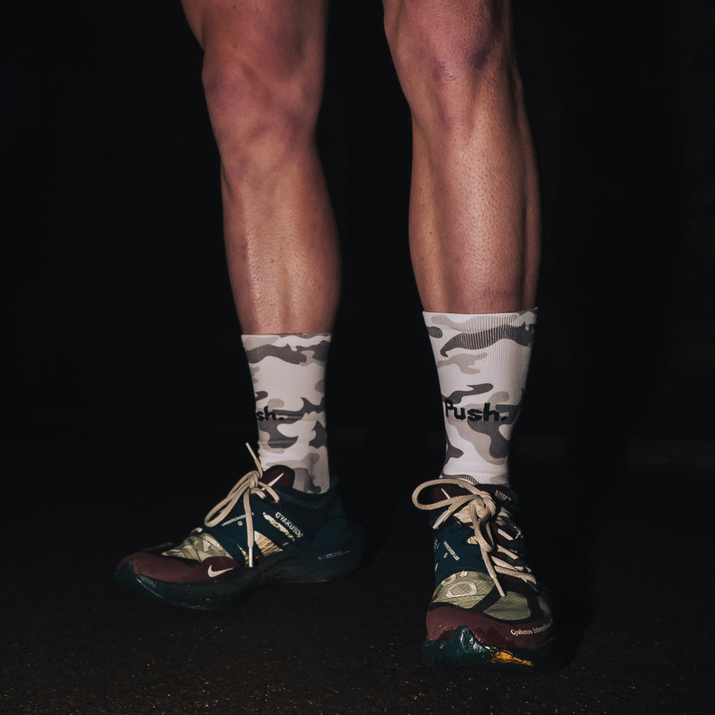 push performance white camo anti-blister running socks being worn by a runner at night time. 