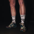 push performance white camo anti-blister running socks being worn by a runner at night time. 