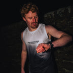 white black mens running vest being worn by a runner at night time. 