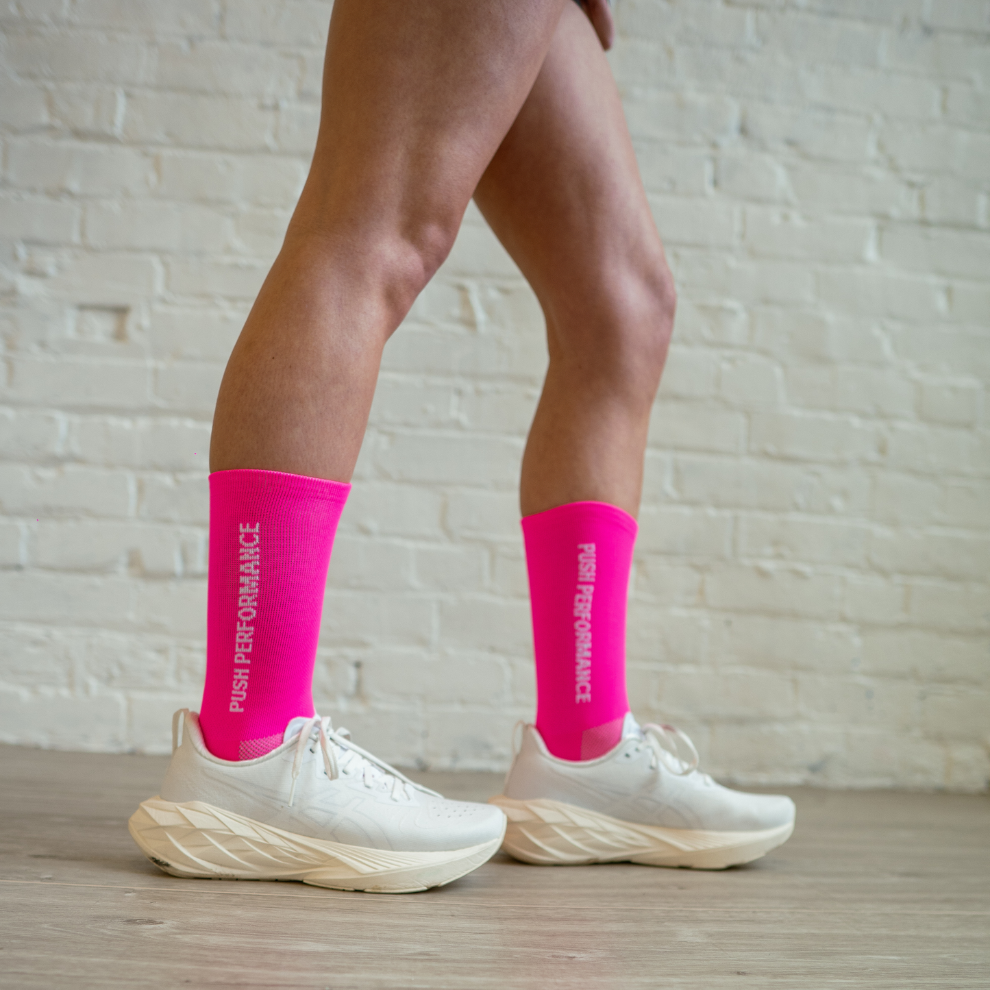 Athlete wearing hot pink Essential Endurance Socks, engineered for performance, grip and long-distance comfort