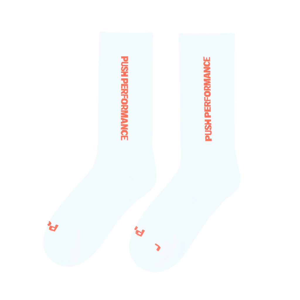 push performance white and orange  anti-blister running socks on white flatlay backgroundnd 