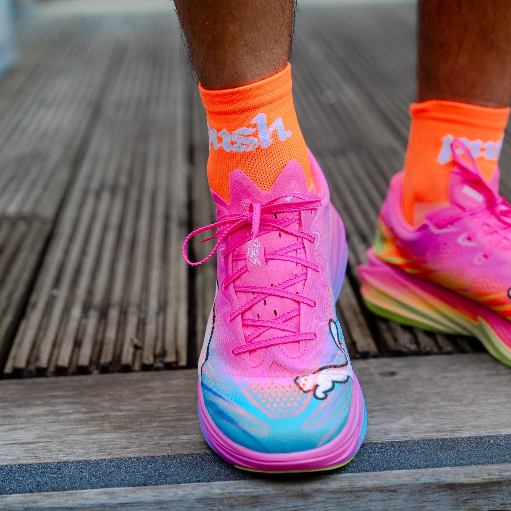 person wearing colourful running shoes with bright orange running socks