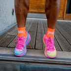 person wearing colourful running shoes with push performance bright orange running socks