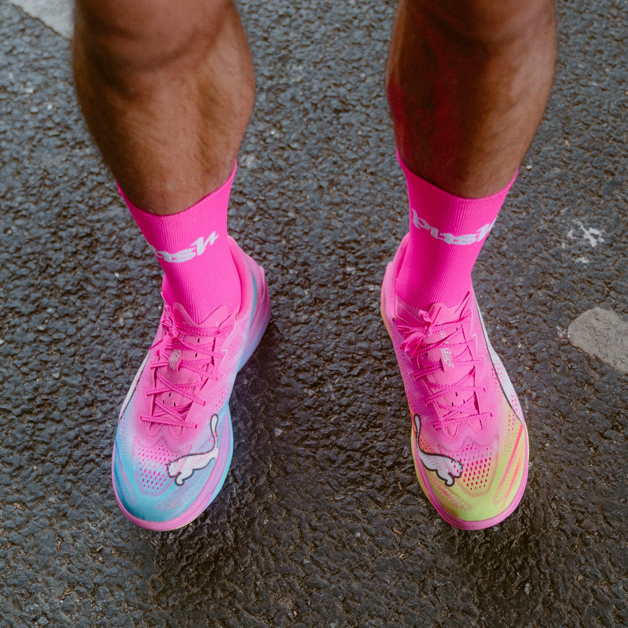 A close-up of a person wearing bright neon pink push performance running socks.