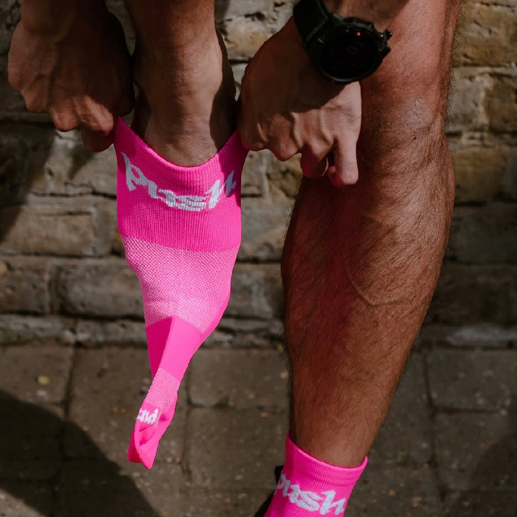 runner stood putting on pink quarter length running socks