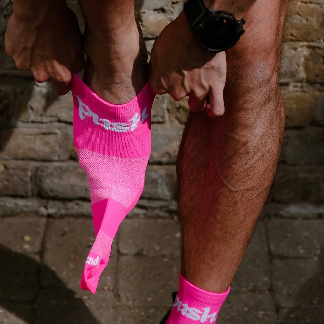 runner stood putting on pink quarter length running socks