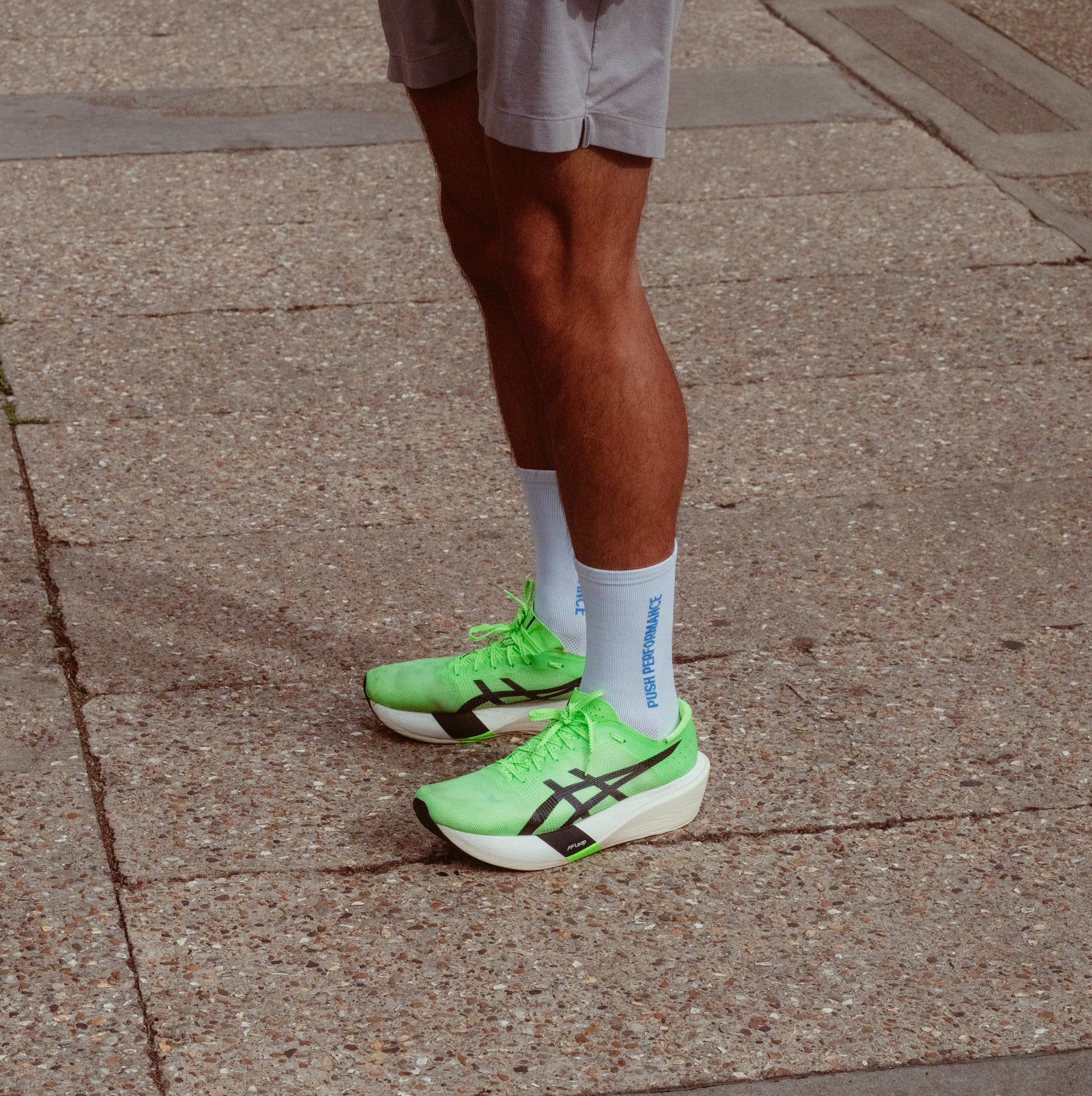 A close-up of a person wearing white and blue push performance running socks.