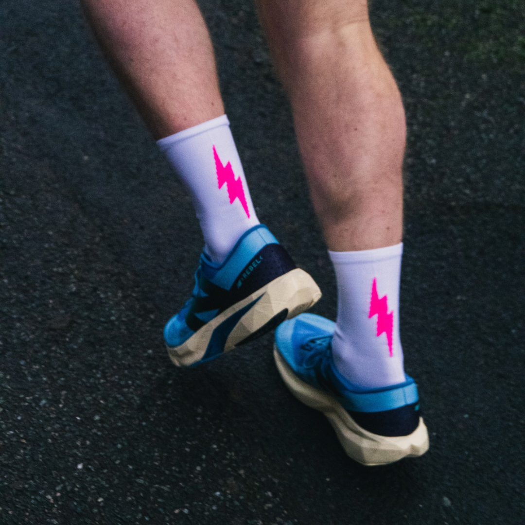 White performance socks with a striking pink bolt design.
