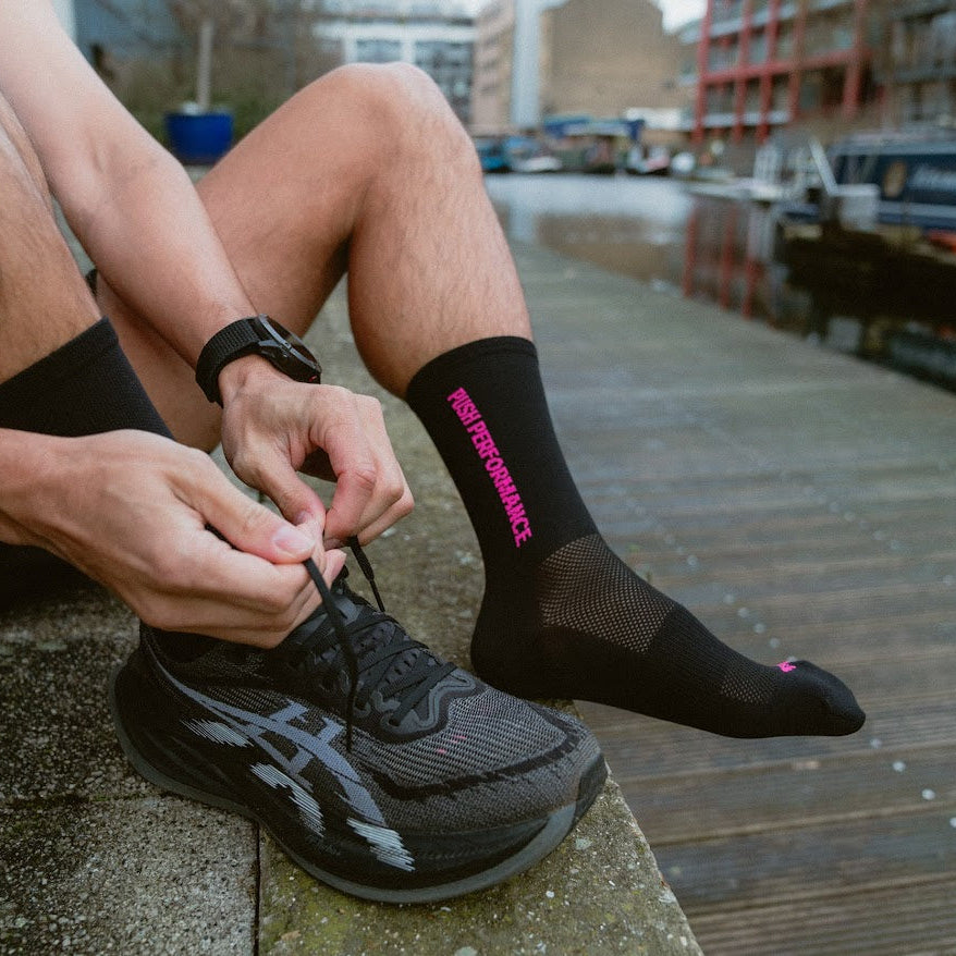 push performance black and pink anti-blister running socks on a runner 